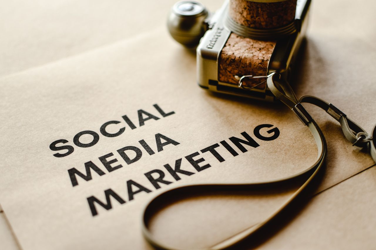 home-services-01 Close-up of a camera placed on brown paper with Social Media Marketing text, emphasizing digital marketing themes.